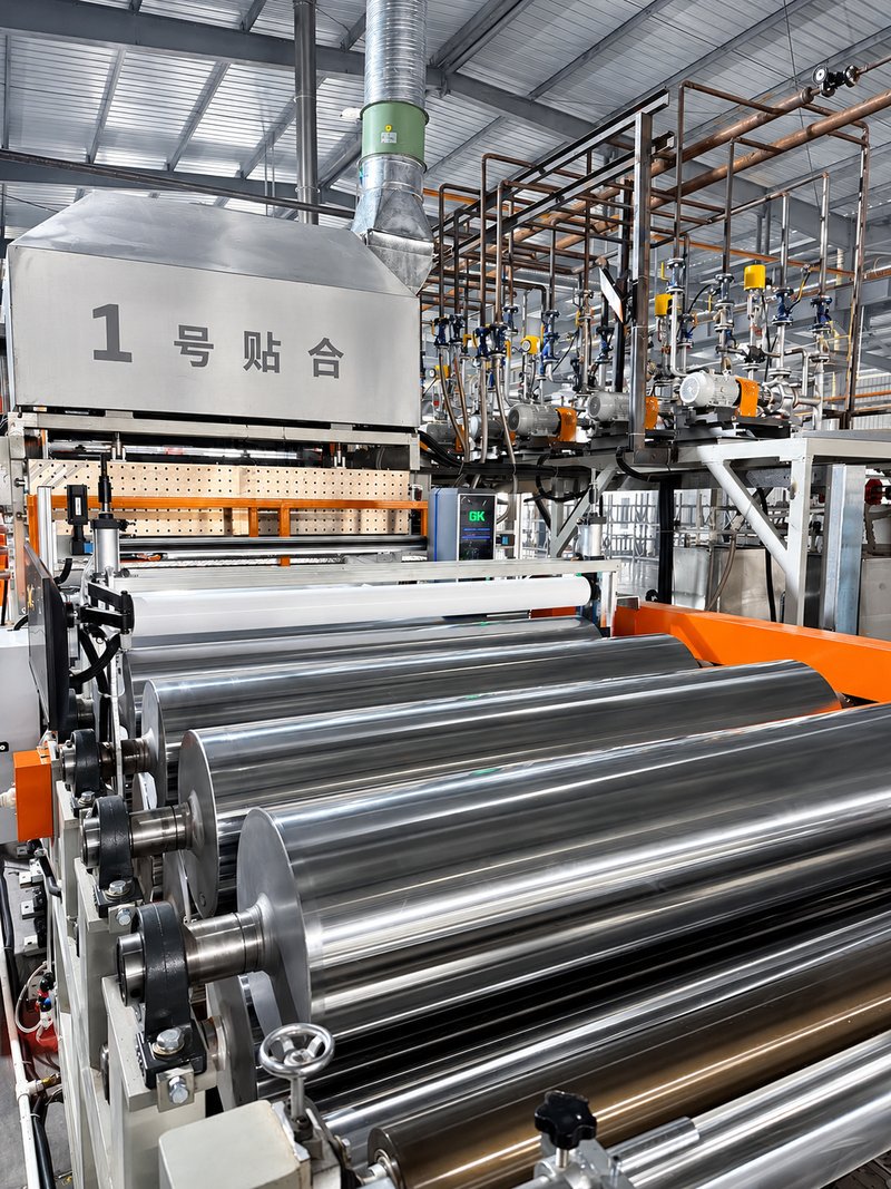 Bonding and coating rollers on decorative-film production line at manufacturing facility in China