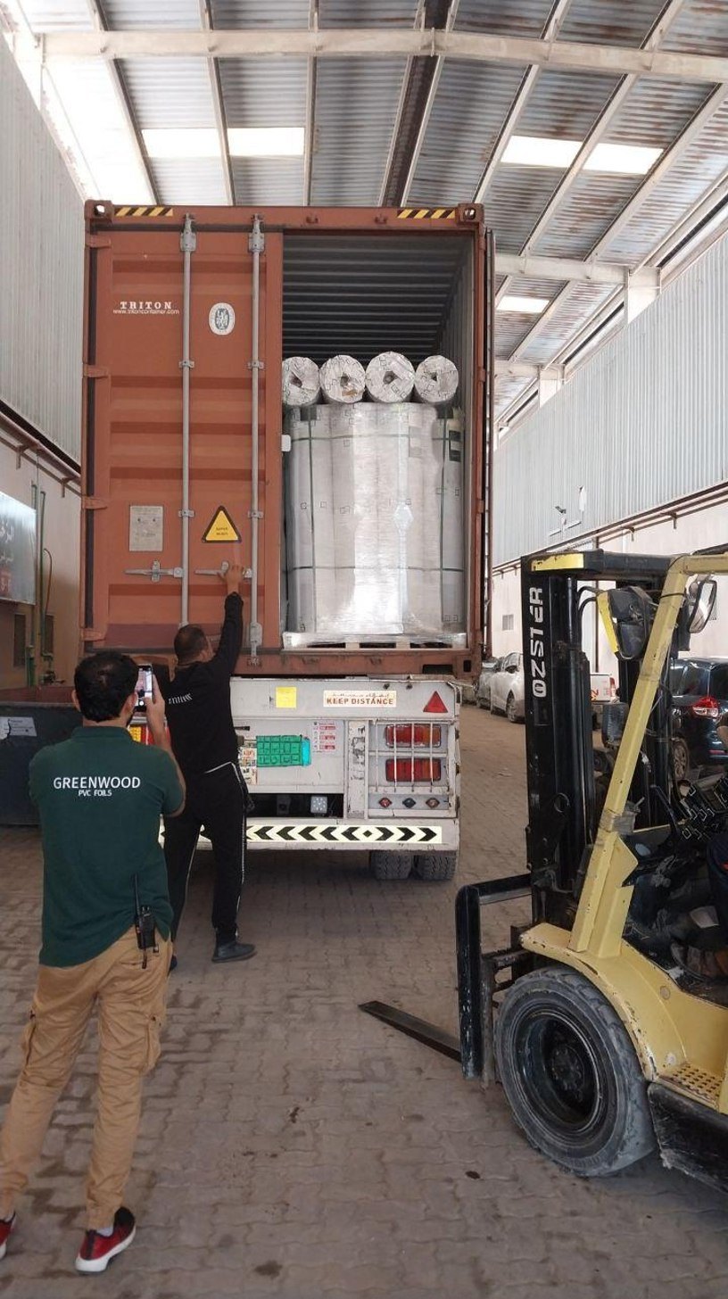GREENWOOD team loading PVC film rolls into a shipping container at the warehouse