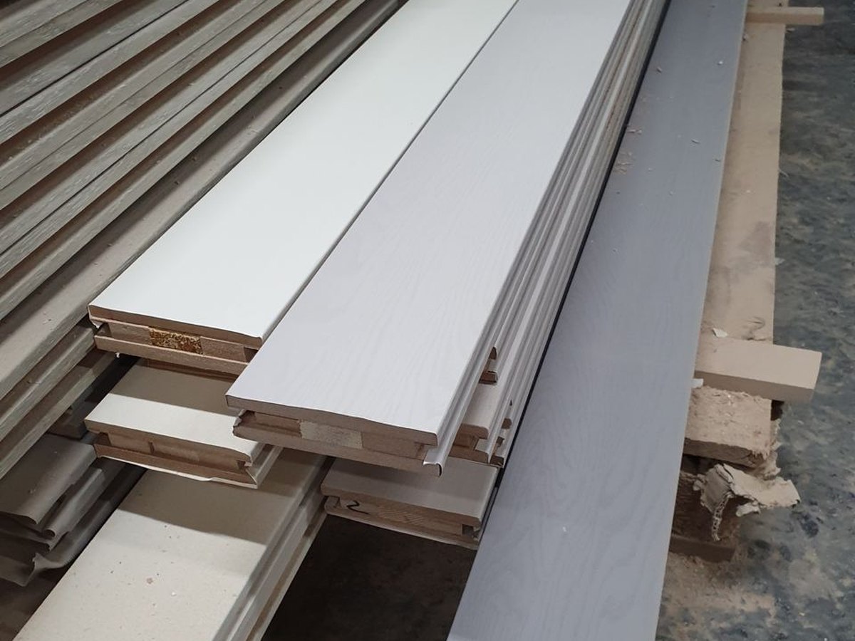 Stacked wrapped profiles with decorative PVC film, showing wrapped edges on linear parts