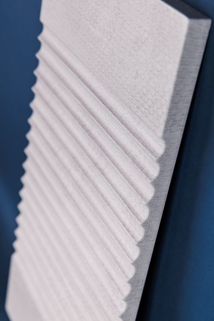 Light fluted decorative panel showing three-dimensional routing under PVC film
