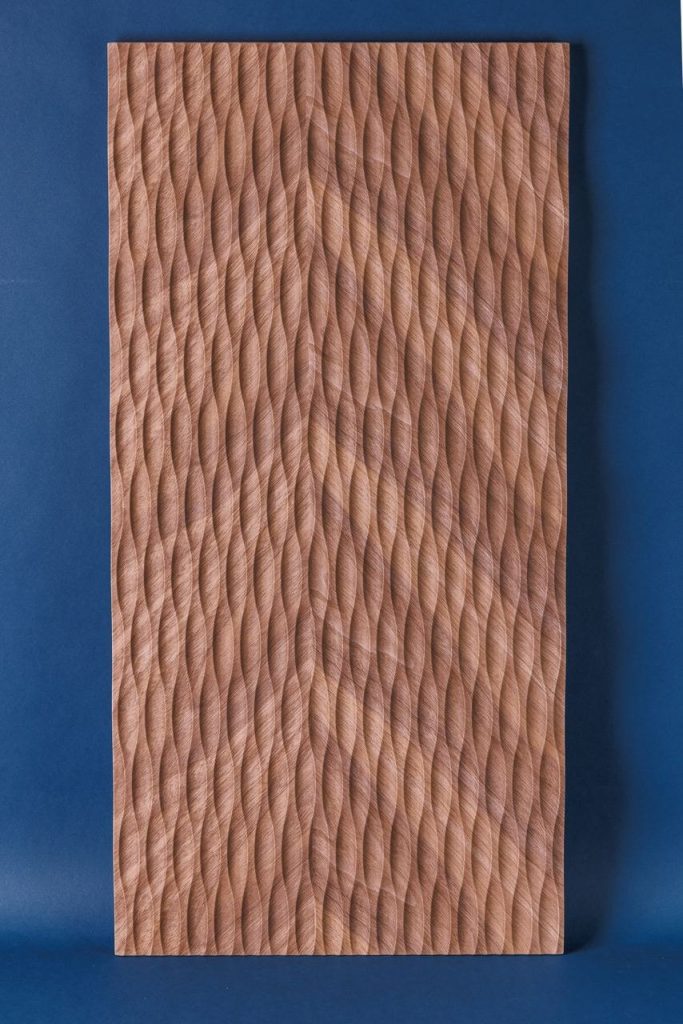 Routed MDF panel with wave texture finished in woodgrain PVC film, studio shot